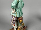 a figurine of a man with a hat and a bag