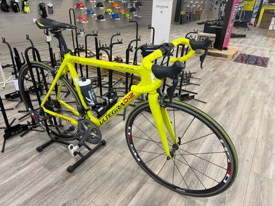 a yellow bike that is sitting in a bike rack