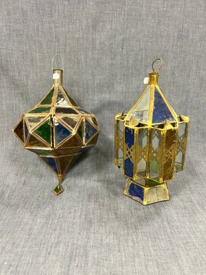 une paire de décorations en vitrail dorées et bleues sur fond gris