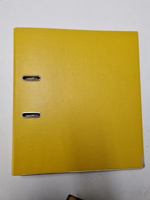 a close up of a yellow binder on a white surface