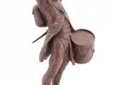 statue of a man holding a drum and a drum stick