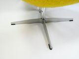 une chaise jaune posée sur une surface blanche