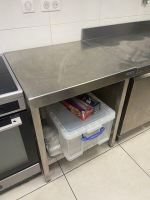 une cuisine équipée d'un plan de travail en inox et d'un micro-ondes