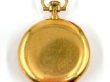 an old gold pocket watch with a chain hanging from it ' s side