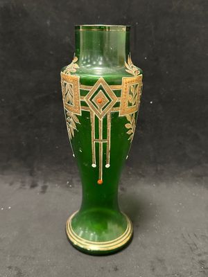 un vase vert posé sur une table sur fond noir