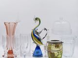 de nombreux vases et verres en verre de différentes couleurs sur la table