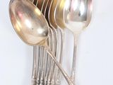 several silver spoons and spoons are stacked on top of each other