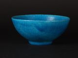 blue bowl with cracky surface on black background against black background