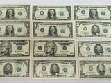 des billets de six dollars sont alignés les uns à côté des autres sur une surface blanche