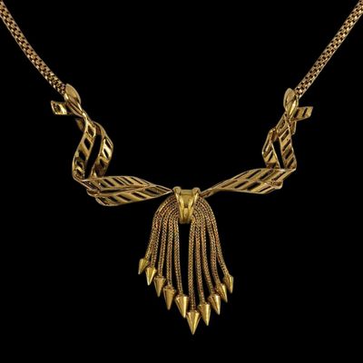 un collier plaqué or orné de pointes et de chaînes sur fond noir