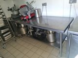 une cuisine avec une table sur laquelle sont posés de nombreux ustensiles de cuisine