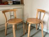 deux chaises en bois assises l'une à côté de l'autre dans une pièce