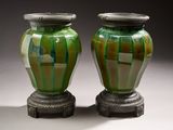 deux vases verts posés l'un à côté de l'autre sur une table