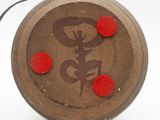 a wooden object with red buttons on it on a white surface