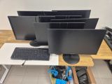 three computer monitors and a keyboard on a desk