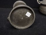 a small metal pot sitting next to a smaller metal pot