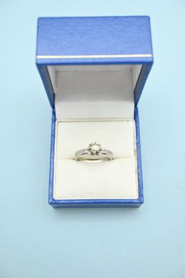 a diamond ring in a blue box on a blue surface