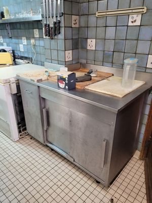 une cuisine avec un plan de travail en inox et un sol carrelé