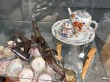 une table en verre avec une vitrine en verre remplie d'objets anciens