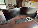 two computer monitors and a keyboard on a desk