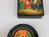 a black plate with a picture on it next to a black vase