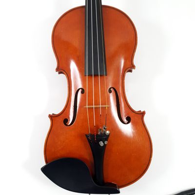 an old violin sitting on top of a white surface next to a bow