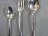 three spoons, a fork, and a spoon on a table