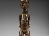 une figurine en bois représentant un homme avec un chapeau sur la tête