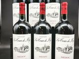 six bouteilles de vin rouge sont alignées sur un comptoir