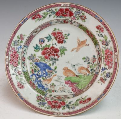 a plate with flowers and birds on it on a table