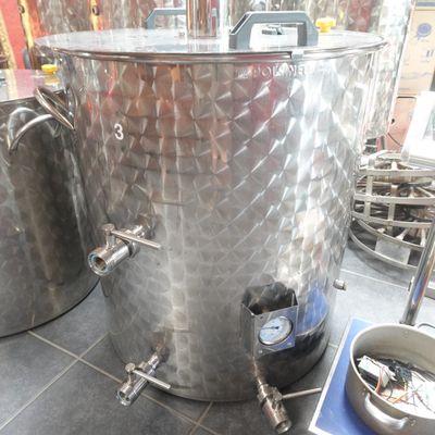 deux grandes cuves en acier inoxydable posées sur un sol carrelé