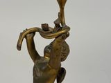 bronze figurine of a boy holding a flower on his head