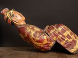 a wooden statue of a woman laying down on a table