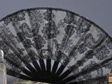 lace fan, perfume, and perfume bottle on a white surface