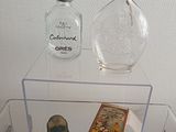a glass display case with a bottle of perfume and a box of perfume