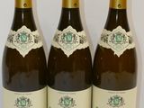 trois bouteilles de vin posées sur une table, l'une à côté de l'autre