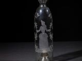 a glass bottle with a picture of a woman inside of it