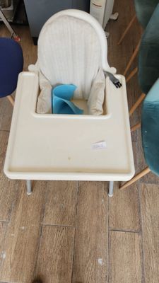 a baby high chair with a tray on the floor