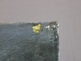 a close up of a piece of metal with a yellow spot on it