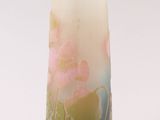 a glass vase with a painting on it sitting on a table