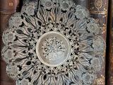 a decorative plate sitting on top of a shelf next to a bunch of books