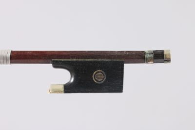 une image représentant un archet de violon posé sur une surface blanche, sur fond blanc