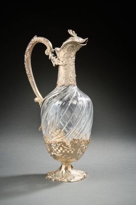 a glass vase with a bird on it on a table