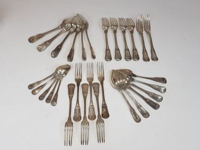 many forks and spoons laid out on the table