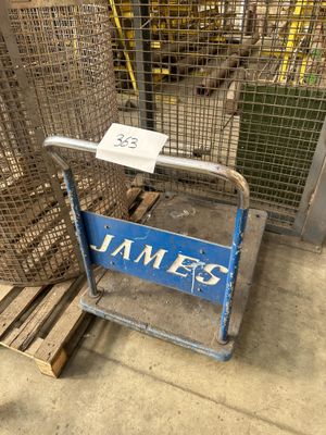 un panneau bleu sur lequel est écrit « jamez », devant une cage