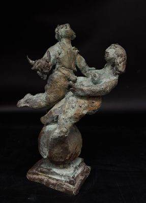 bronze statue of a man sitting on top of a rock