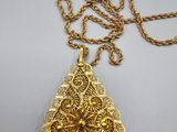 a gold plated necklace with a leaf pendant on a chain