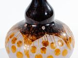 a black and gold vase sitting on a white surface