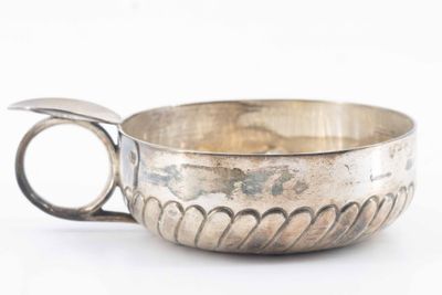 a silver cup with a handle on a white surface