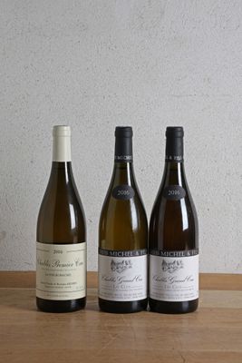 trois bouteilles de vin sont alignées sur une table en bois